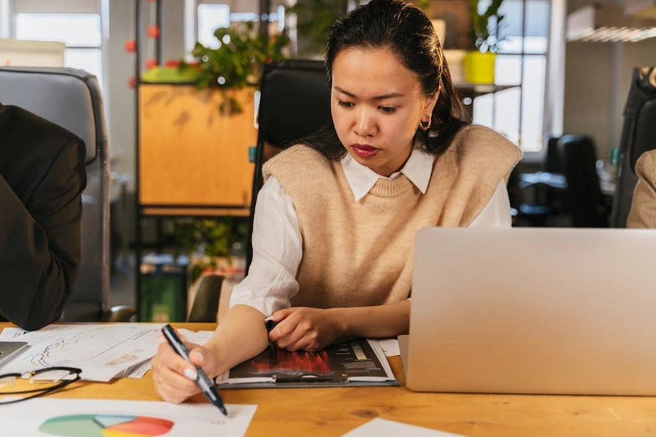 Usmívající se student s notebookem analyzuje grafy.